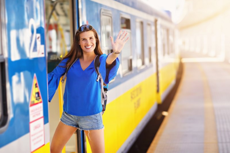 giovane donna sorridente turista prende treno vscanza estate